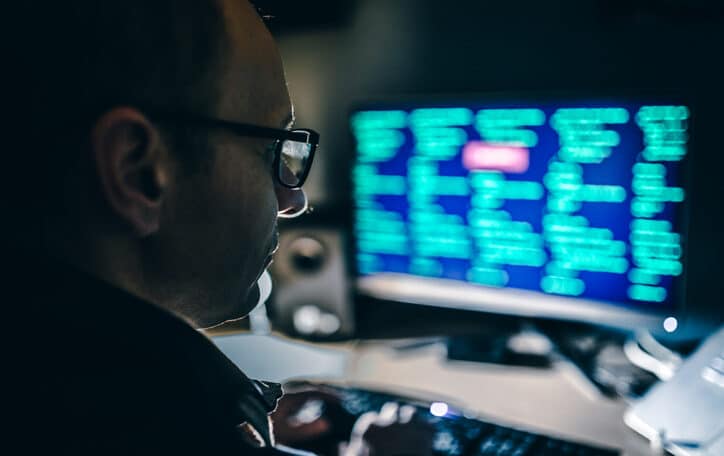 Hacker using a computer in a dark room