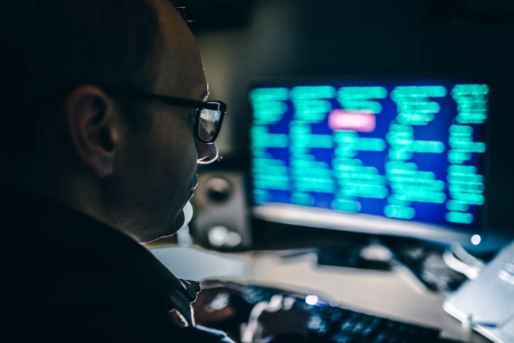 Hacker using a computer in a dark room